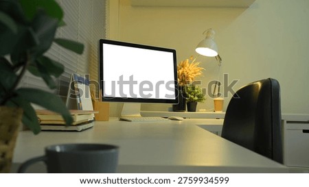 Side view desktop computer mockup on office desk with lamp and night lighting.