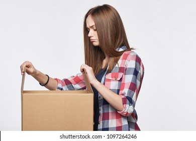 Side View A Discontent Disappointed Girl Opening A Box Looking At Camera