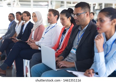 Side View Of Diverse Audience Listening To Speaker In A Business Seminar. International Diverse Corporate Business Partnership Concept