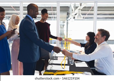 Side view of diverse Business people checking in at conference registration table. International diverse corporate business partnership concept