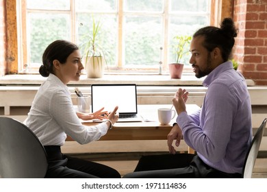 Side view diverse colleagues working on project together, Indian businesswoman and African American businessman discussing strategy, sitting at desk with laptop with white empty screen mockup - Powered by Shutterstock