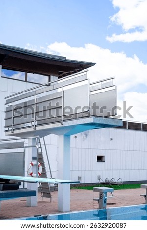 Side view of the diving board in an outdoor swimming pool against the sky
