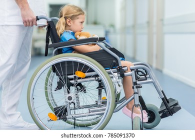 side view of doctor moving kid on wheelchair - Powered by Shutterstock