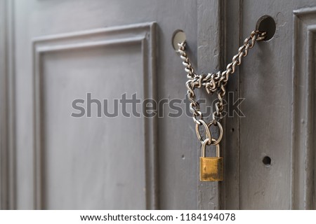 A side view of a door locked with chains and a padlock. Building and security as a concept