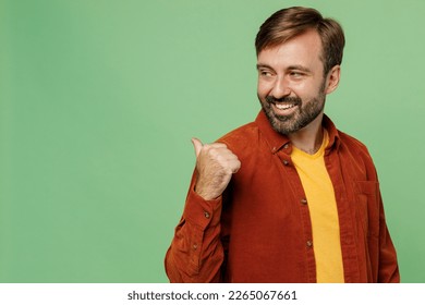 Side view elderly caucasian man 40s years old wears casual clothes red shirt t-shirt point thumb finger aside indicate on workspace copy space mock up isolated on plain pastel light green background