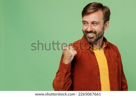 Side view elderly caucasian man 40s years old wears casual clothes red shirt t-shirt point thumb finger aside indicate on workspace copy space mock up isolated on plain pastel light green background