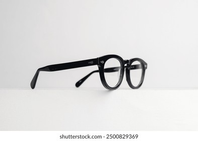Side view of elegant black glossy glasses on white background.
