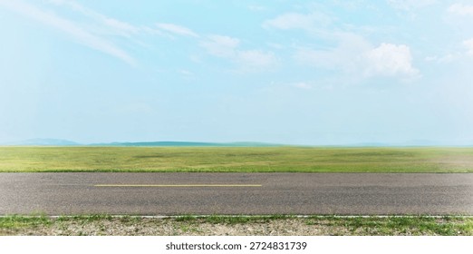 Side view of empty asphalt road and green field