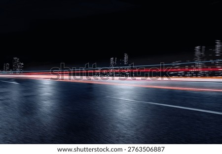 Side view of an empty night highway with fast horizontal motion blur light trails.