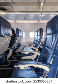 Side View of Empty Seats Inside an Airplane Cabin with Windows Visible During Boarding