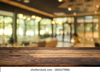 Side View Of Empty Space Wooden Table Top With Abstract Blurry Coffee Shop Or Cafe Restaurant In Background For Product Showing And Advertising.