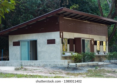 A Side View Of The Entrance To A Public Restroom Located In A Park.