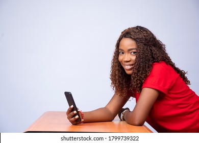 Side View Of Excited Young African Lady Using Her Phone