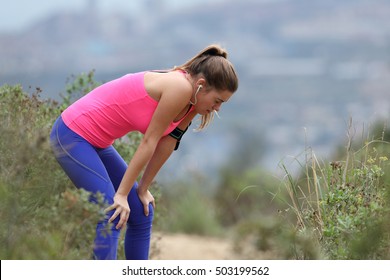 Side view of an exhausted runner wearing colorful sportswear resting in after run