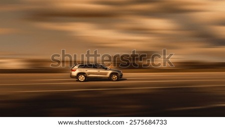 Side view of a fast moving car. SUV on a speeding blurred background in brownish tones.
