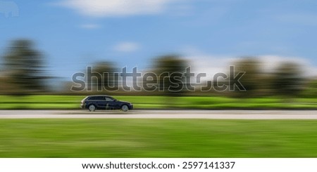 Side view of a fast moving car with a blurred background.