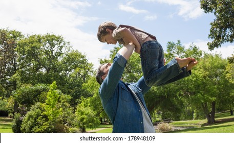 Side view of a father carrying son at the park