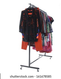 Side View Female Clothes With Coat And Trousers Hanging On Clothes Rack On White