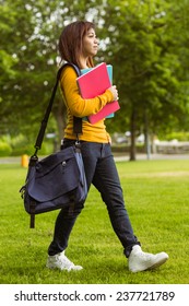 Side View Of Female College Student With Books Walking In The Park