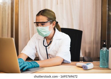 Side View At Female Doctors In Protective Mask And Safety Goggles Using Laptop To Examine File With Experiment Result While Working, 
Concept Virus Protection