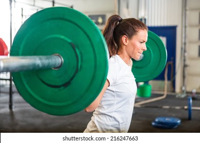 Side View Of Fit Young Woman Lifting Barbell In Fitness Box