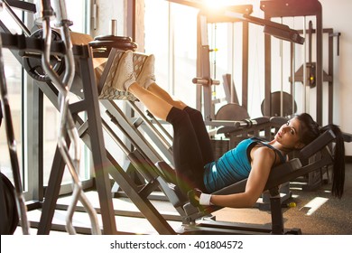 Side view of a fit young woman doing leg presses in the gym. - Powered by Shutterstock