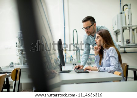 Side view of focused students using desktop pc in classroom at Technical faculty