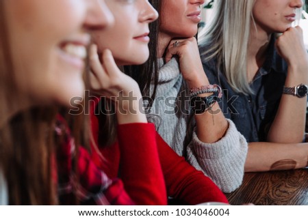 Side view of a Four smiling friends sitting by the table in cafe
