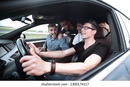 Side View . Friends Sitting In The Car And Looking At The Camera.