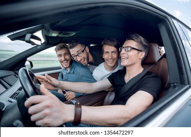 Side View . Friends Sitting In The Car And Looking At The Camera.