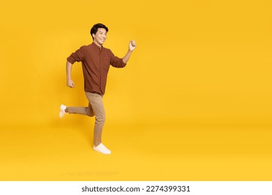 Side view of full length portrait of Asian young businessman walking isolated on yellow background - Shutterstock ID 2274399331
