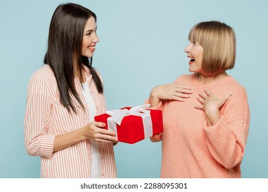 Side view fun amazed elder parent mom with young adult daughter two women together wear casual clothes hold present box with gift ribbon bow isolated on plain blue cyan background. Family day concept - Powered by Shutterstock