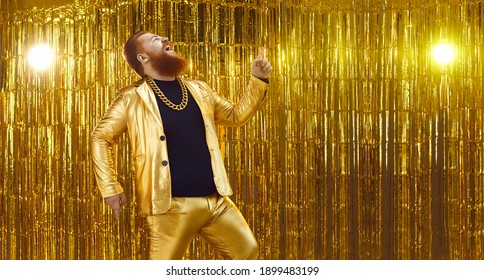 Side View Of Funny Crazy Uninhibited Chubby Young Man In Golden Suit Singing Songs And Having Fun At Disco Club Or Karaoke Party. Website Banner With Shiny Gold Background And Free Space For Text