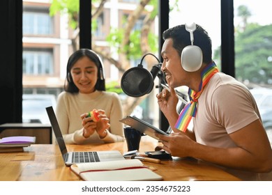 Side view of gay man content creator in headphone talking through microphone for recording conversation for channel