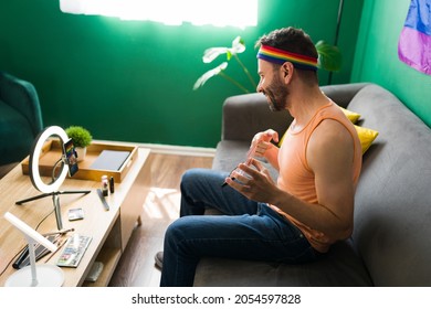 Side view of a gay young person doing his makeup for a video tutorial with a ring light and smartphone at home  - Powered by Shutterstock