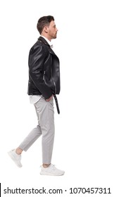 Side View Of Going  Handsome Man In A Leather Jacket And Trousers. Walking Young Guy . People Collection.  Backside View Of Person.  Isolated Over White Background. The Rocker Goes Past The Frame