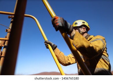 Side View Good Safety Practice Of Male Miner Wearing Safety Helmet Protective Gear Walking Up Stair Holding A Hand Rail With Three Point Of Contact While Working On Construction Mine Site, Sydney