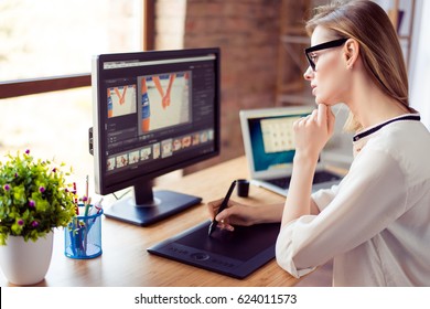 Side view of graphic designer working with interactive pen display, digital drawing tablet and pen on a computer in workstation - Powered by Shutterstock