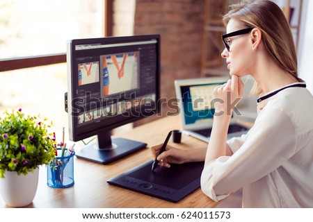 Side view of graphic designer working with interactive pen display, digital drawing tablet and pen on a computer in workstation
