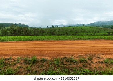Side view of gravel road in countryside with meadow - Powered by Shutterstock