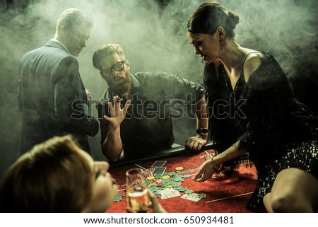 side view of group of people playing poker together in casino