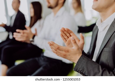 Side view of group of young cheerful people sitting on conference together and applauding - Shutterstock ID 1255001053
