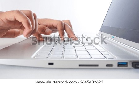 Side view of hands of a man typing on laptop keyboard isolated on white background