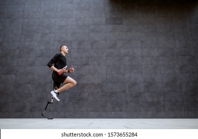 Side view of handsome fit caucasian sportsman with artificial leg running outside. - Powered by Shutterstock