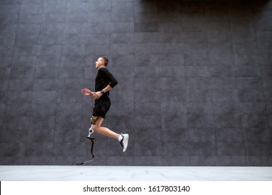 Side View Of Handsome Fit Caucasian Sportsman With Artificial Leg Running Outside.