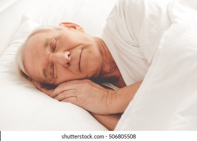 Side View Of Handsome Old Man Sleeping In Bed