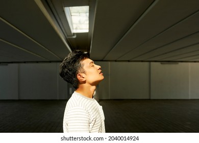 Side view of handsome young man breathing out getting ready for filming view on underground parking - Powered by Shutterstock