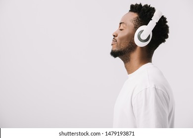 Side View Of Happy African American Man Listening Music In Headphones On White