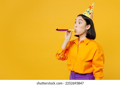 Side view happy fun surprised excited cool young woman wearing casual clothes celebrating blowing pipe look camera spread arms isolated on plain yellow background. Birthday 8 14 holiday party concept - Powered by Shutterstock