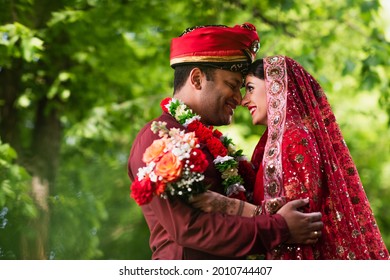 Side View If Happy Indian Man In Turban Hugging Bride In Red Sari